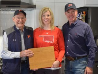 Alumus and retired instructor Lloyd Looper keeps history alive through a cutting board gift to Kelly Faltyn made from a desk estimated to have been built in 1948. — Photo by Meghan Gates
