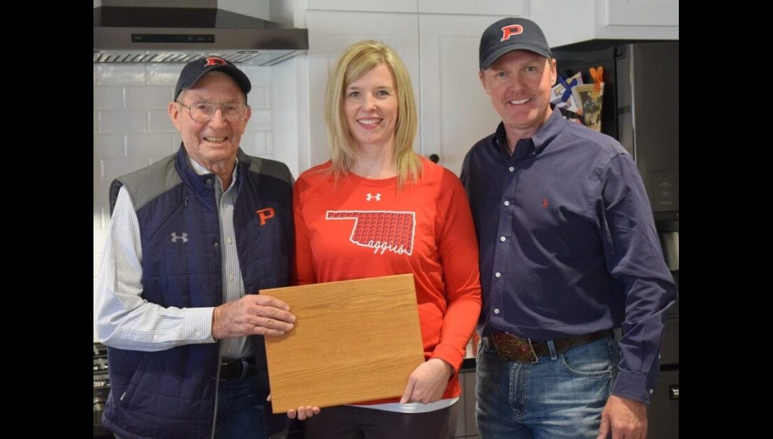 Alumus and retired instructor Lloyd Looper keeps history alive through a cutting board gift to Kelly Faltyn made from a desk estimated to have been built in 1948. — Photo by Meghan Gates