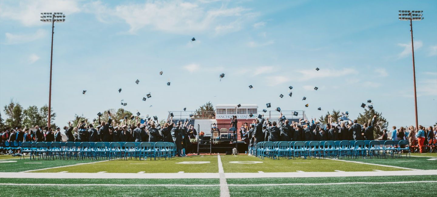 Graduates throw caps into the air