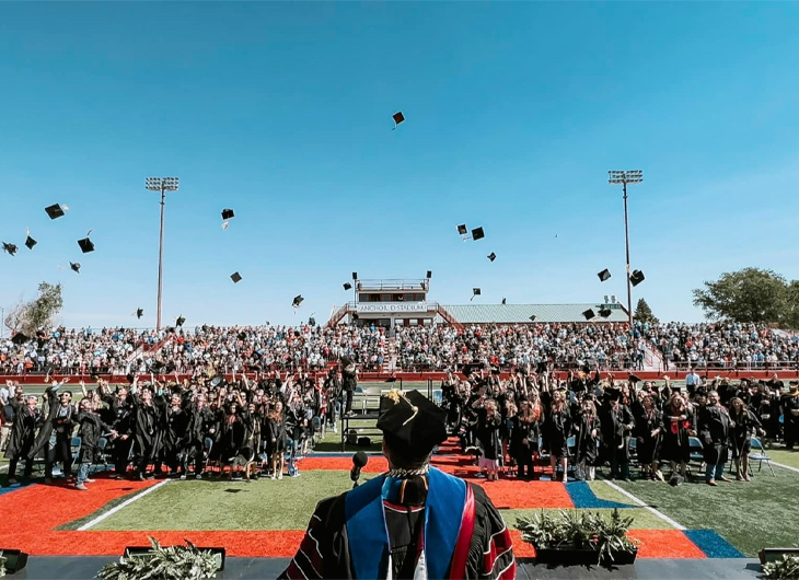 Graduates tossing caps into the air