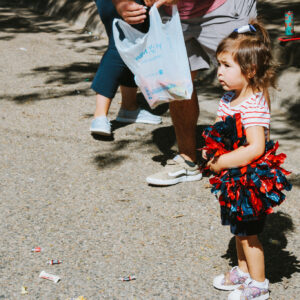 Little girl holding red and blue pompoms at OPSU parade..