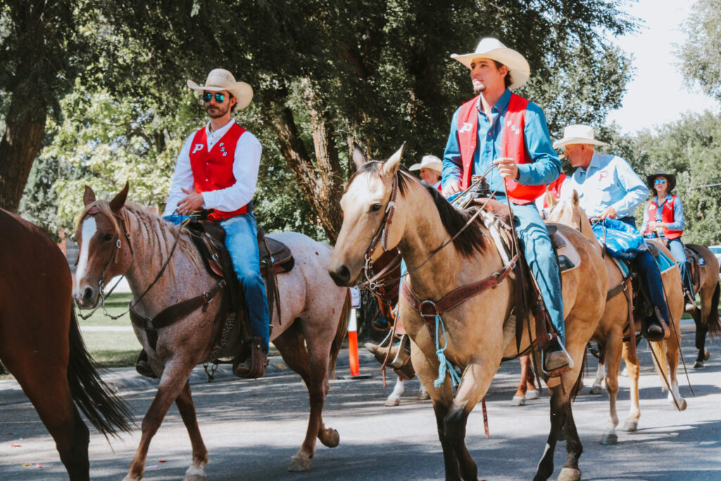 Rodeo team members riding their horses in the parade.