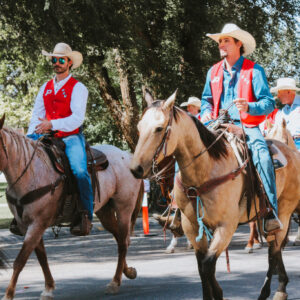 Rodeo team members riding their horses in the parade.