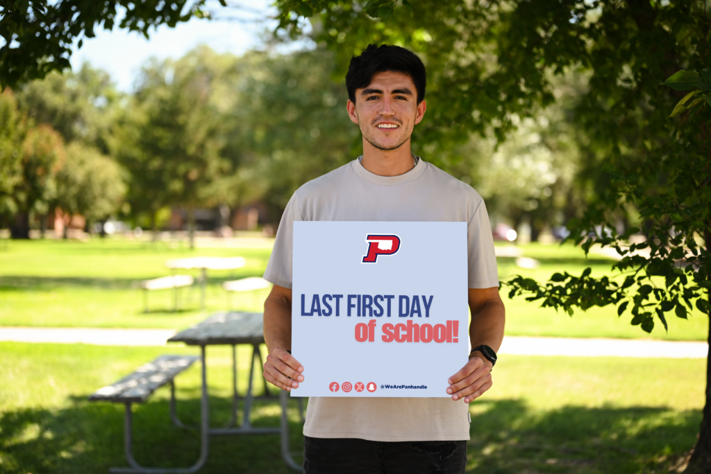 OPSU Student Holding a Sign that says, "Last First Day of School". 